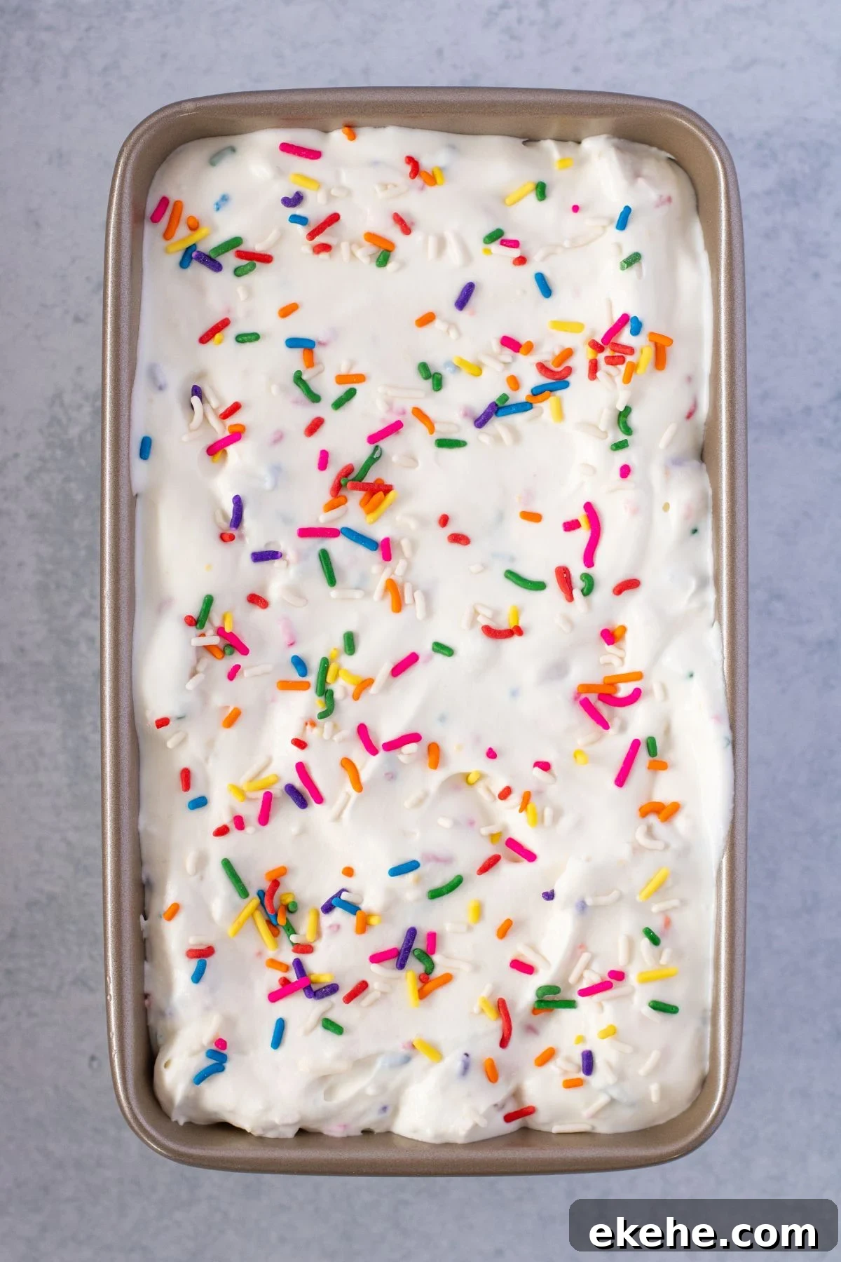 Golden Oreo Ice cream in a metal loaf pan topped with sprinkles.
