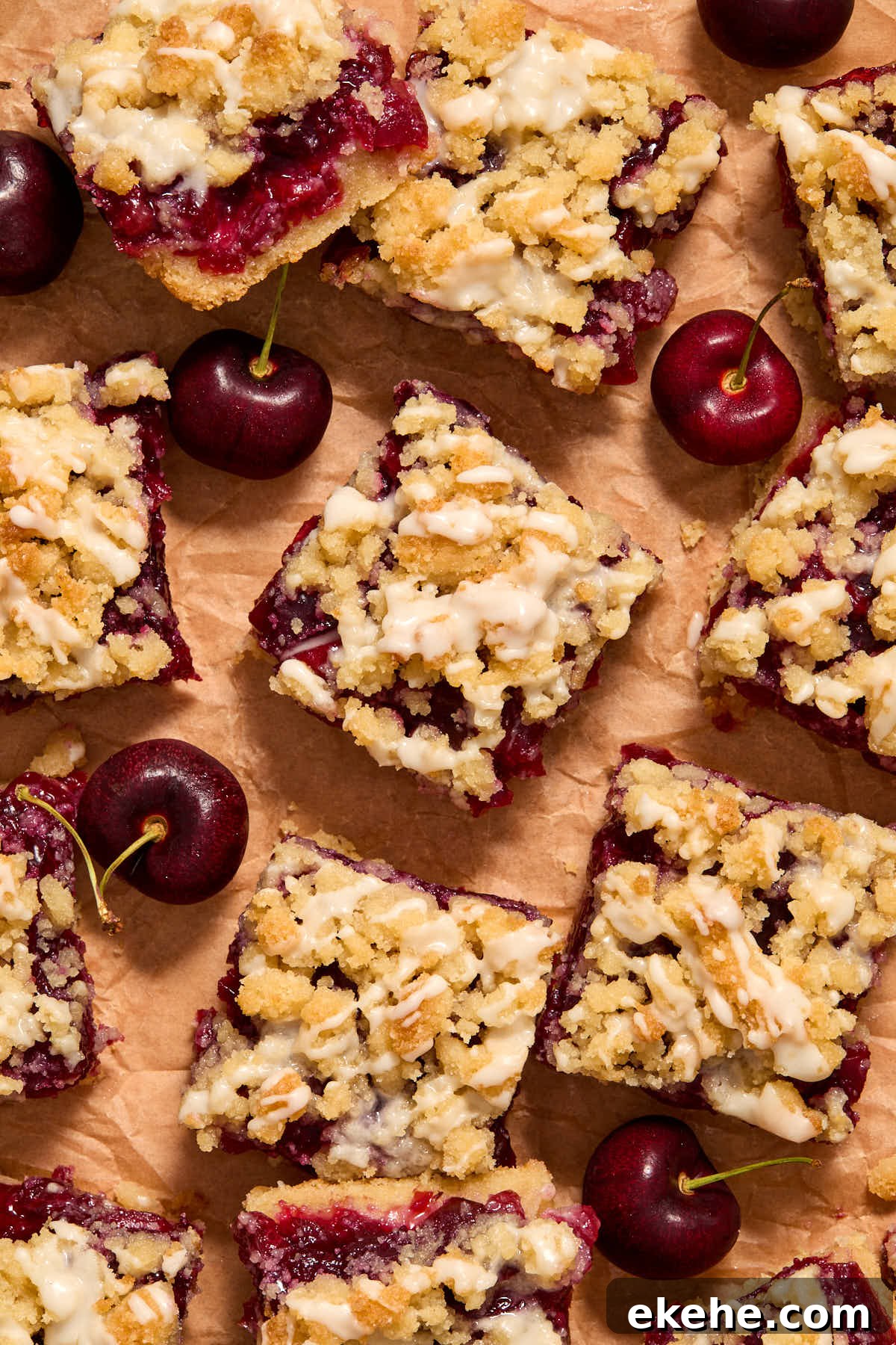 Overhead view of cherry pie bars arranged on brown parchment paper.