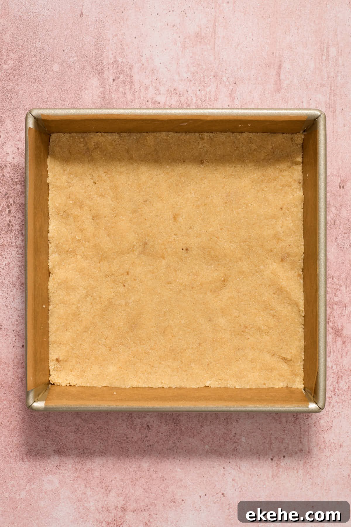 Crust mixture pressed into the bottom of a square pan.