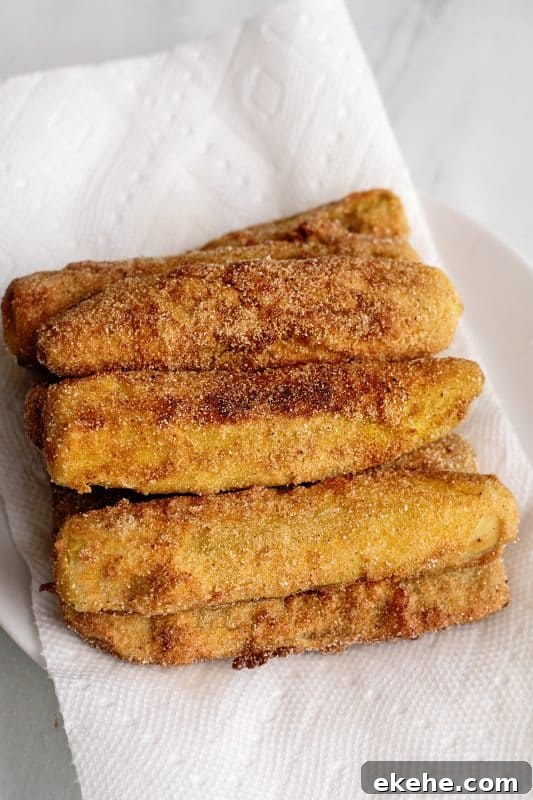 Fried dill pickles on paper towel-lined plate.