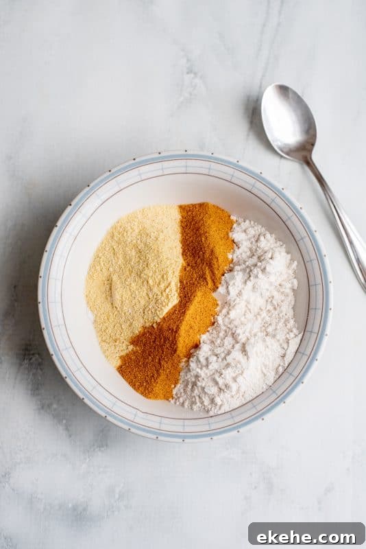 Place cornmeal, some flour, and seasoned salt in bowl and stir.