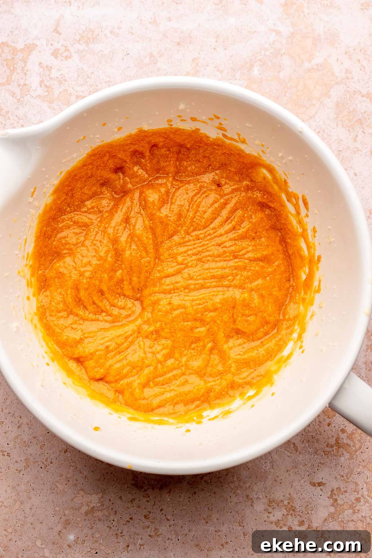 Creamed pumpkin cake batter in a bowl.