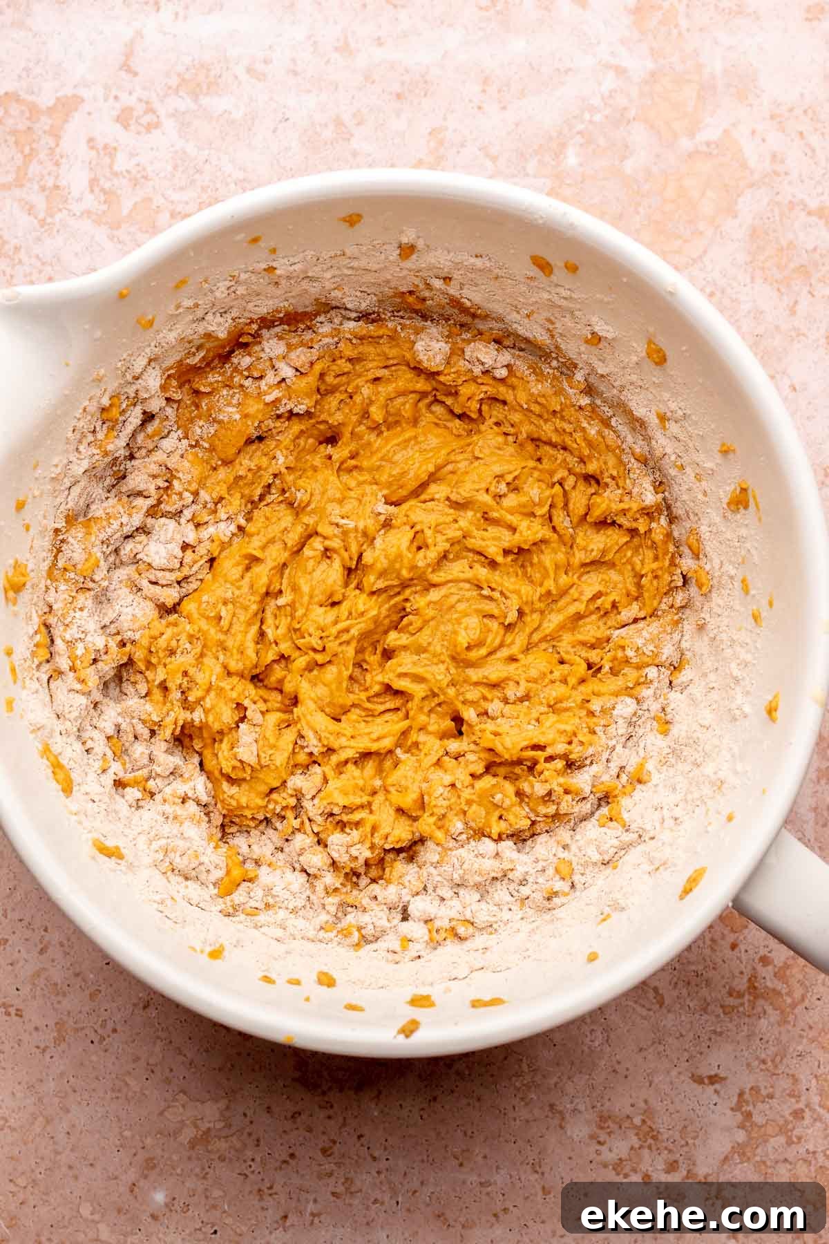 Half mixed pumpkin cake batter in a bowl.