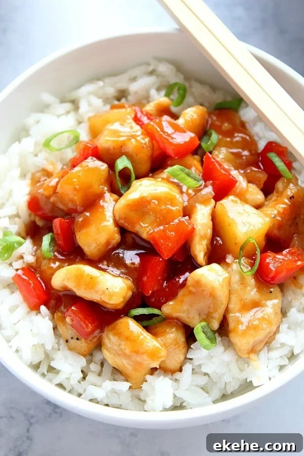 Sweet and Sour Chicken with rice in white bowl.