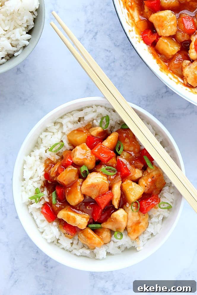 Chicken and peppers on top of rice in bowl.