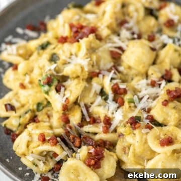Fork dipped in corn pasta on grey plate.