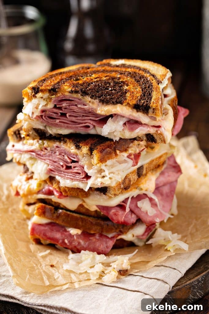 Corned beef sandwiches cut in half and stack on top of parchment paper