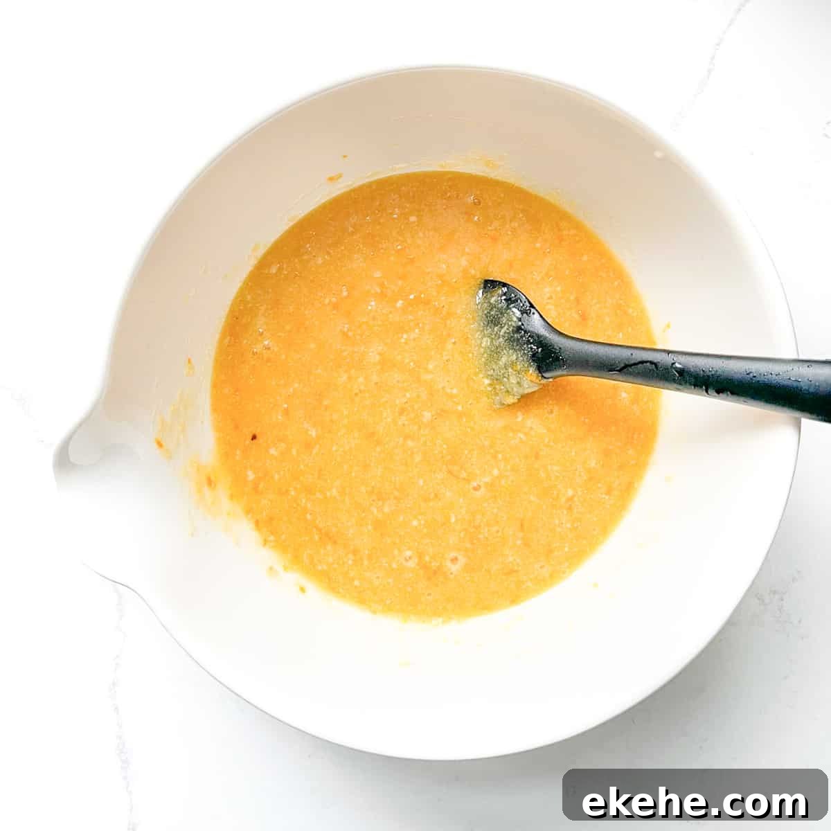 Mixed batter for the Tunisian cake in a large white bowl.