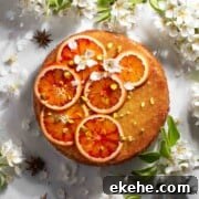 Tunisian cake with sliced oranges on top, surrounded by blossoms.