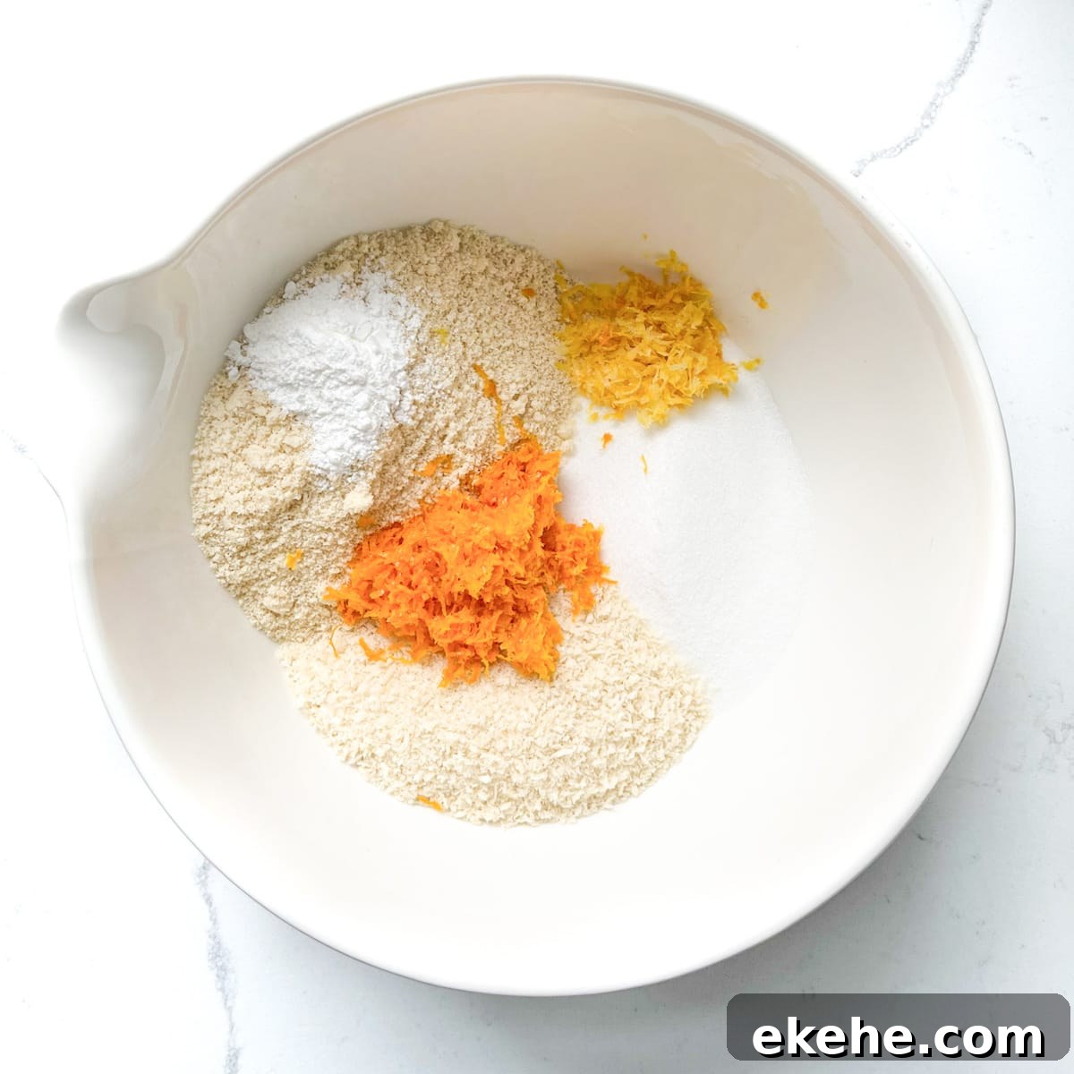 All the dry ingredients for the Tunisian cake in a large white mixing bowl.