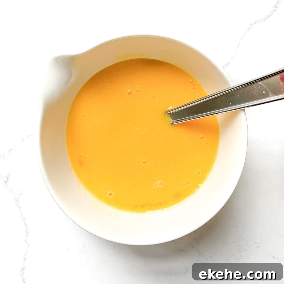 A bowl of whisked eggs and oil for the Tunisian cake.