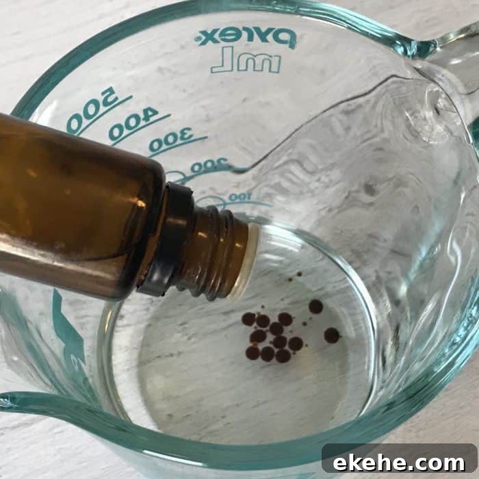 adding vanilla oleoresin to coconut oil in glass measuring cup
