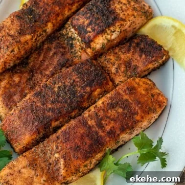 Four grilled salmon fillets on a serving platter