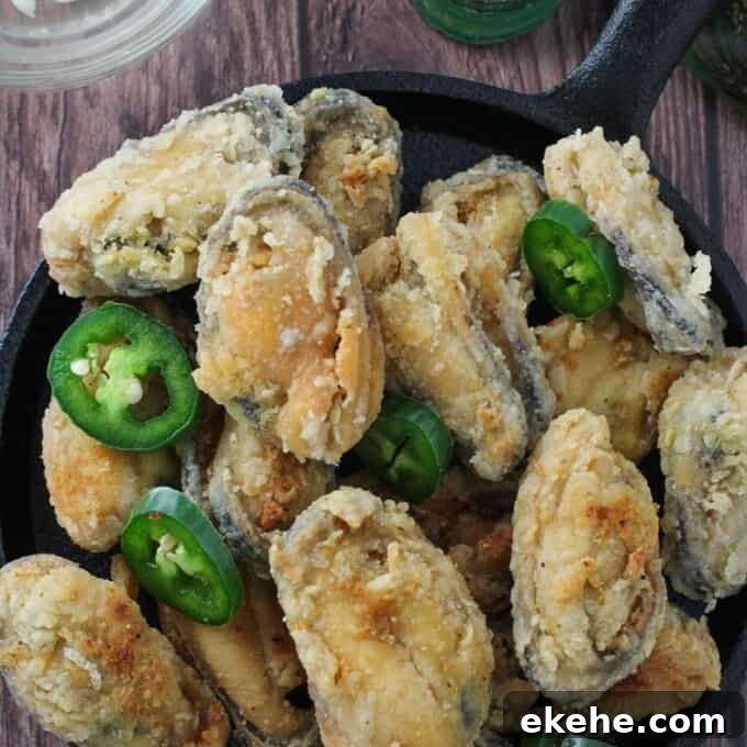 crispy tahong with sliced jalapenos on a cast-iron skillet