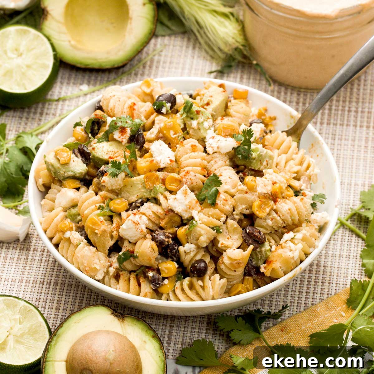 A bowl of pie protein Mexican street corn pasta salad with avocado and cilantro.