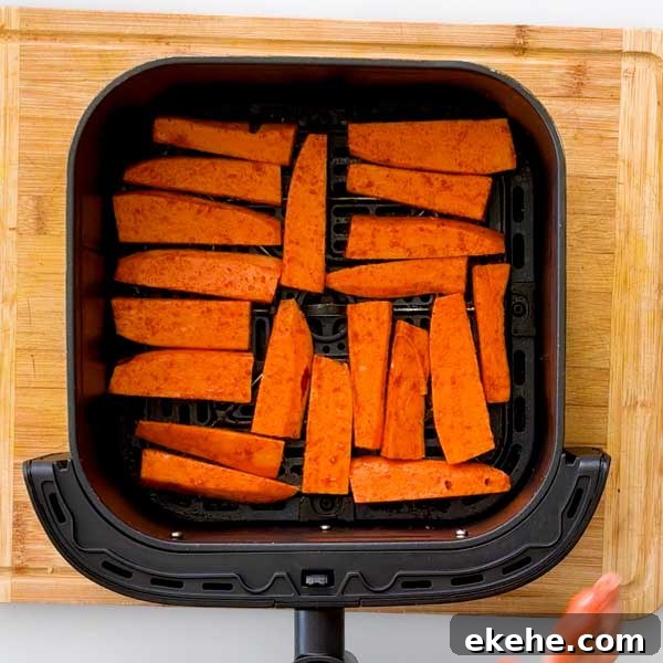Spreading wedges out in the air fryer in a single layer with space around them.