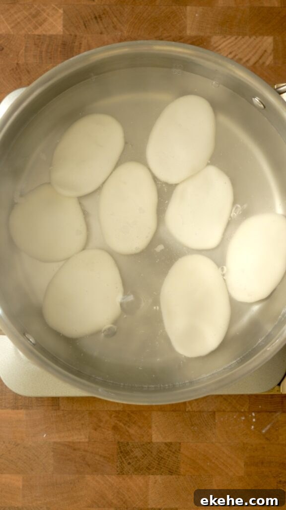 Palitaw discs freshly put in boiling water sink to the bottom of the pot