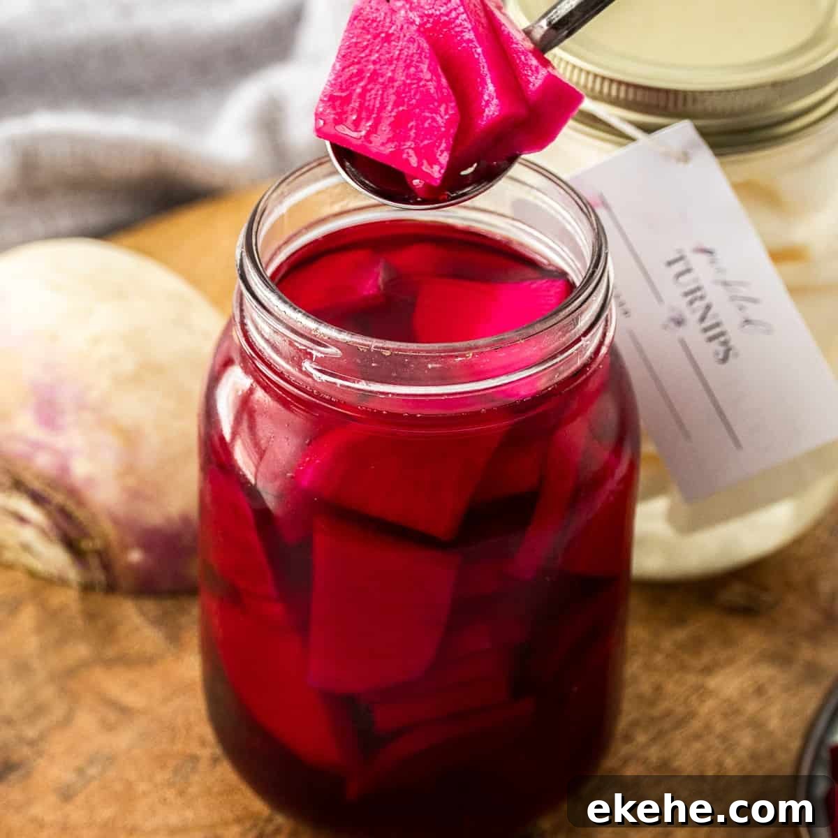 Spoon lifting some Beetroot Pickled Turnips out of the jar.