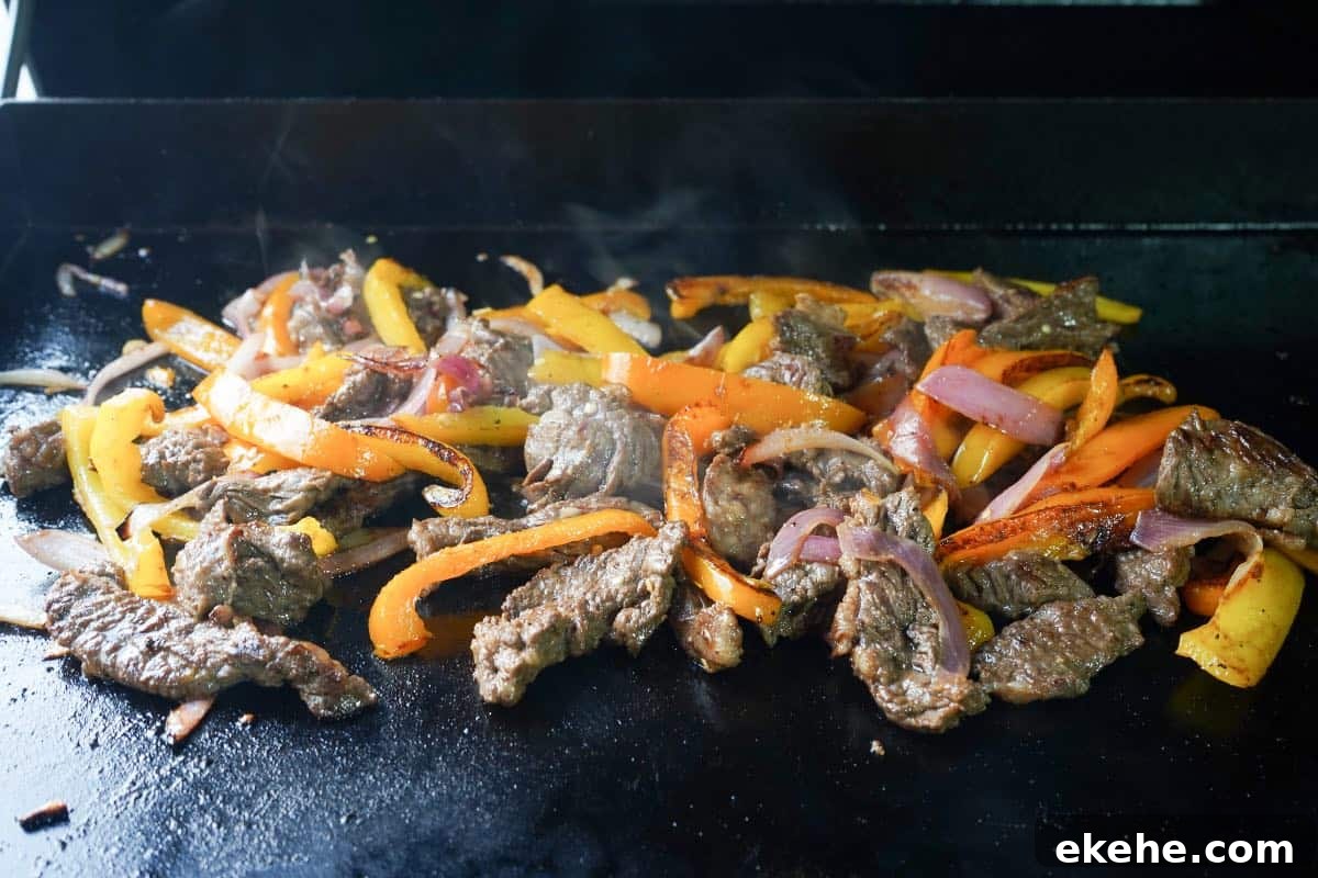 marinated Skirt Steak and veggies for fajitas cooked on the blackstone or flat top