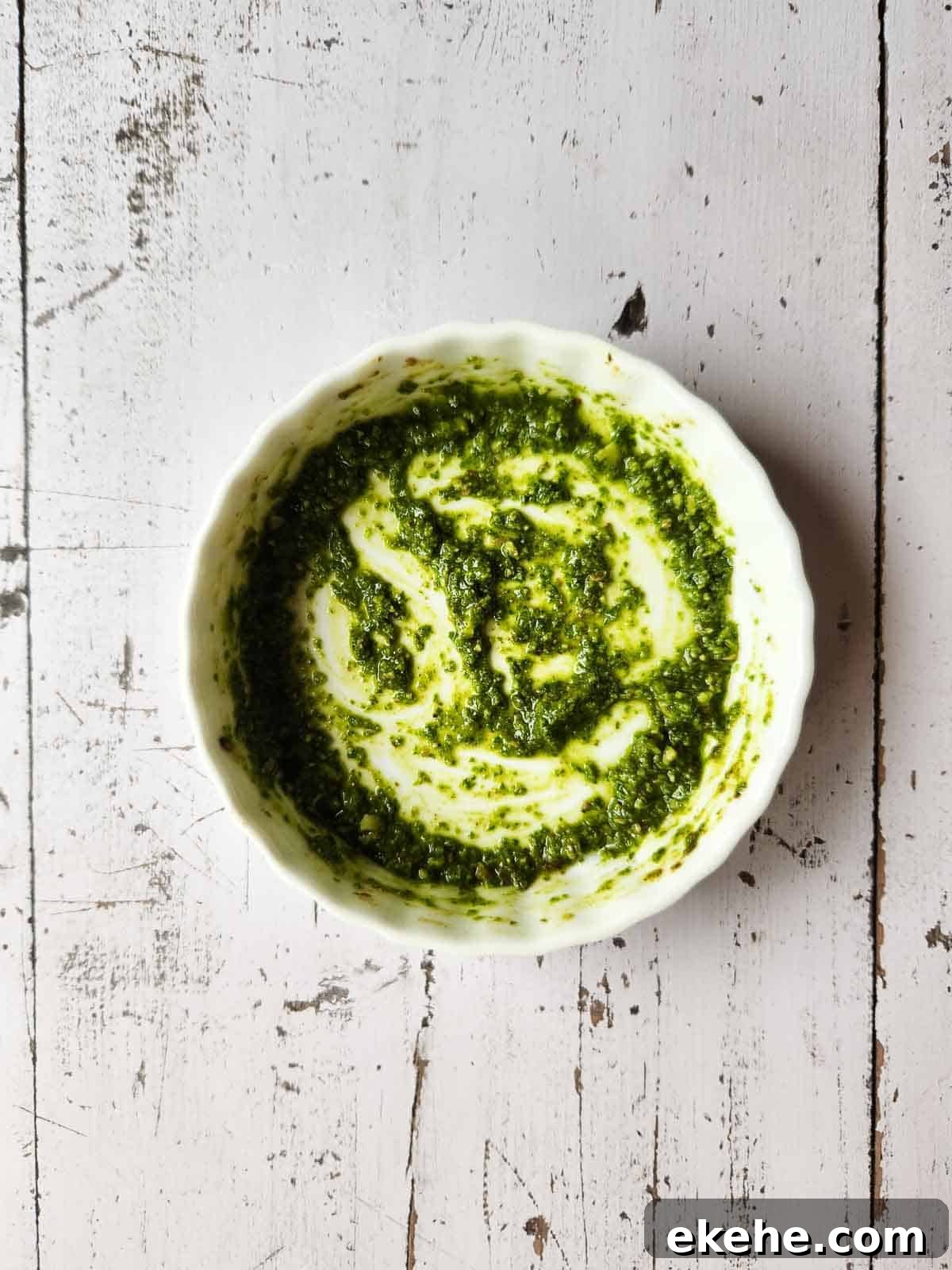 Pesto sauce in a white ramekin.