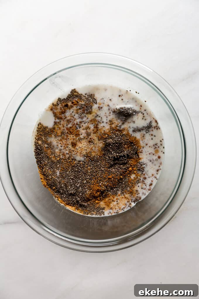 chia seeds, coconut milk and spices in a clear mixing bowl