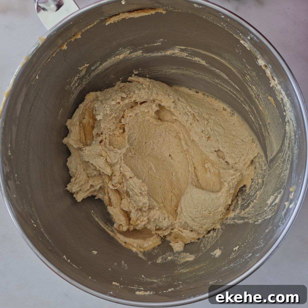 creamed butter and brown sugar in the bottom of a stainless steel bowl.