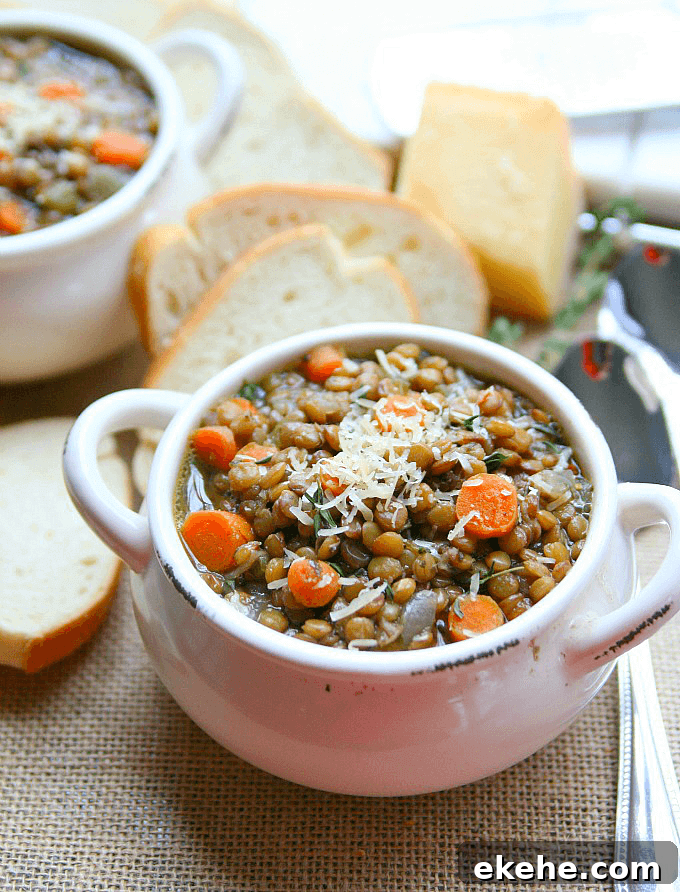 Lentil soup in a bowl with french bread on the side.