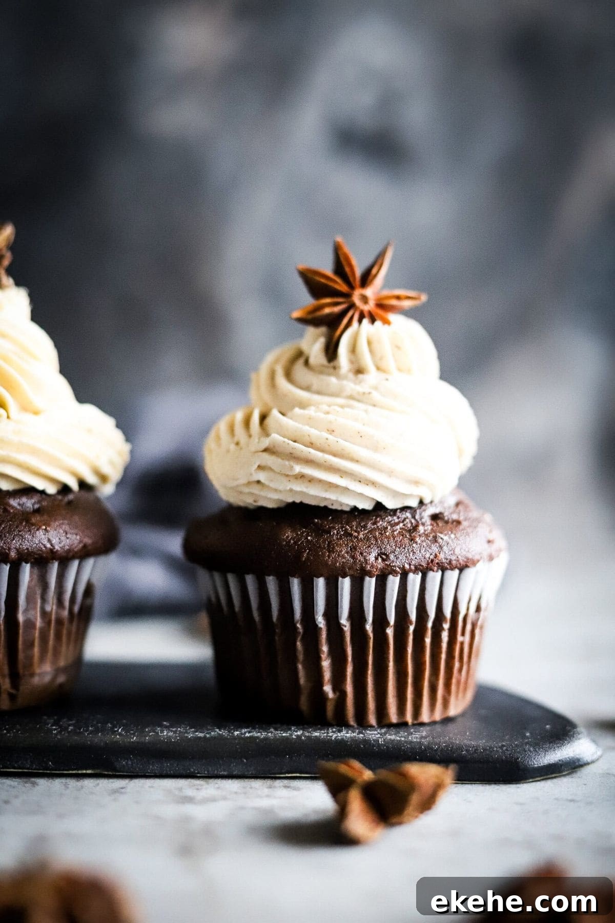 An eggless chocolate cupcake with swirled cream frosting, topped with a decorative star anise.