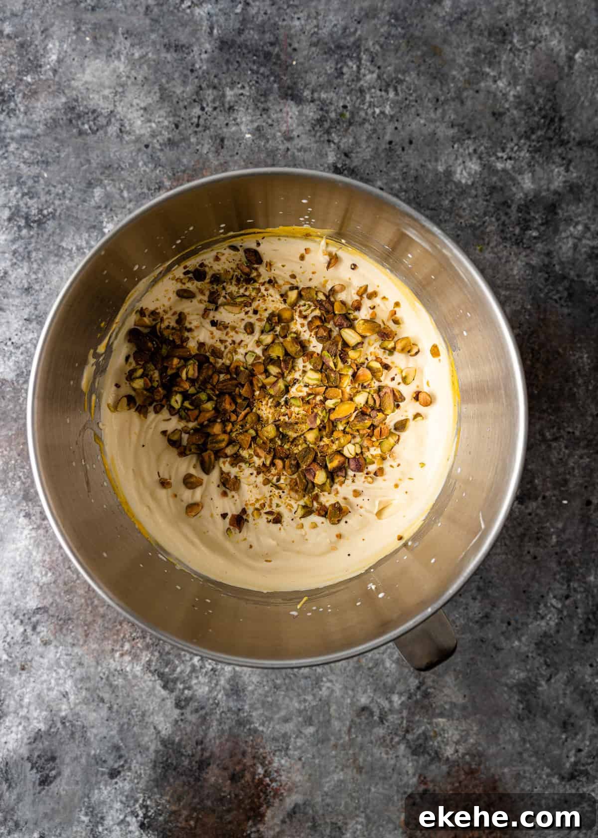 overhead process shot: adding crushed pistachios to the saffron ice cream mixture