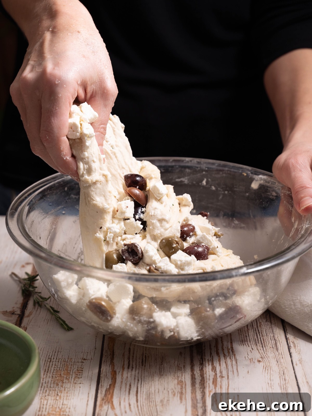 Folding olives and feta into sourdough bread