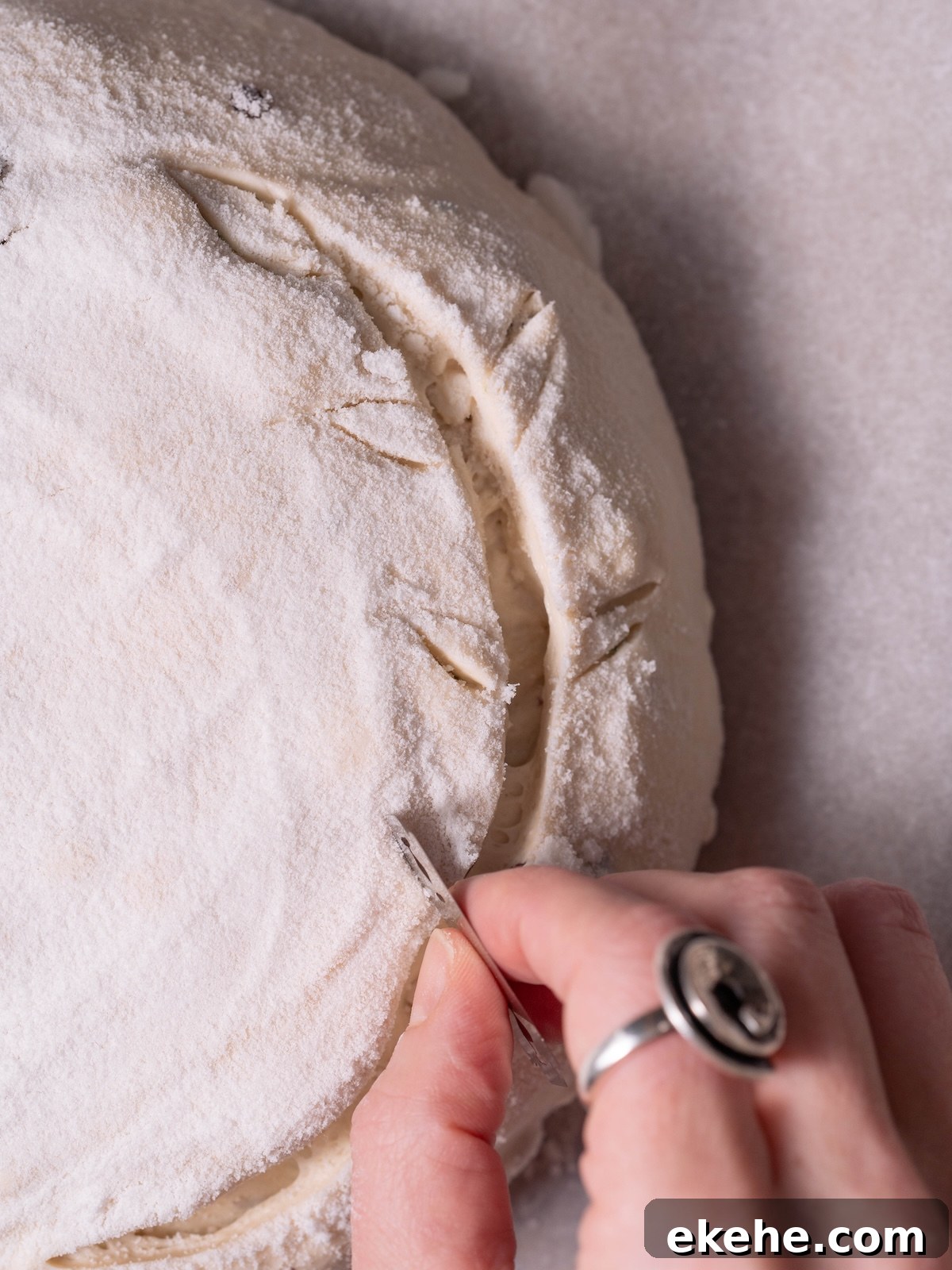 Scoring sourdough with an olive branch pattern
