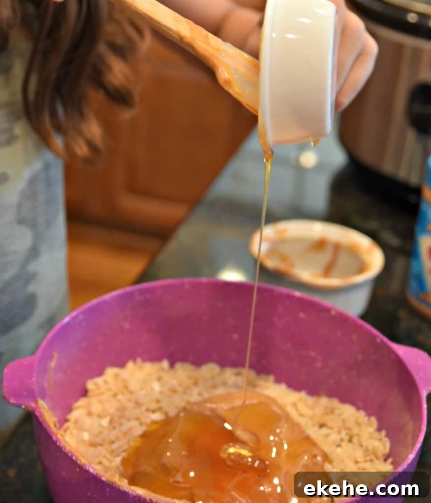 pouring honey into a bowl with rice krispies peanut butter and oats