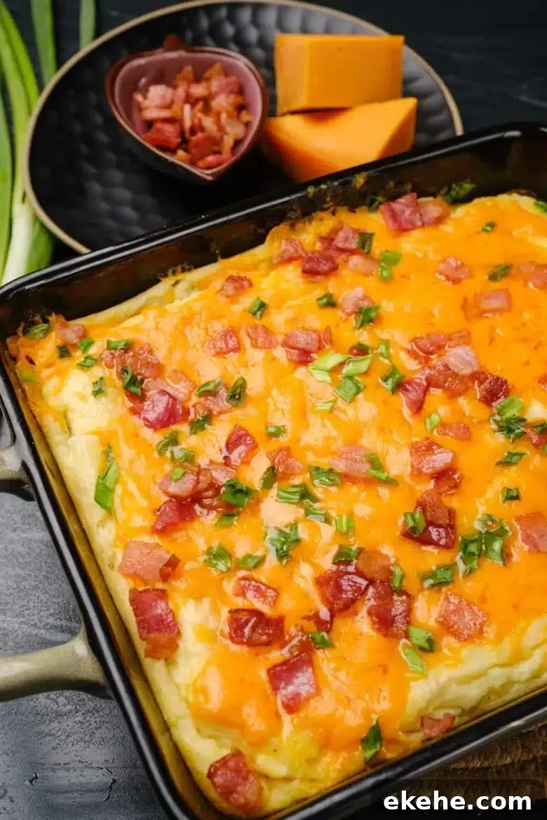 baked mashed potatoes with melted cheese, bacon, and sliced green onions on top. 