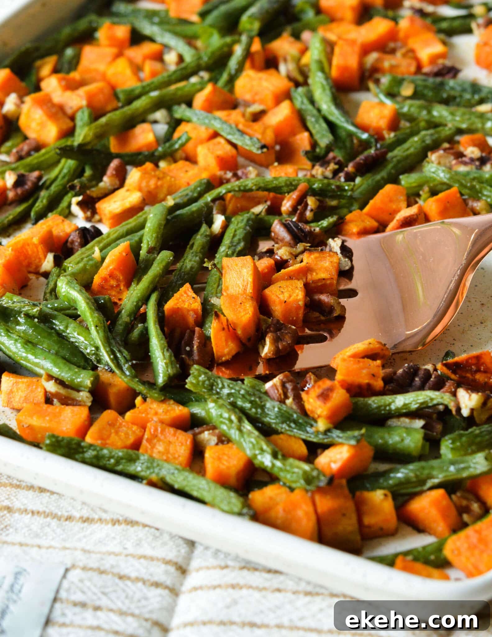 roasted green beans and sweet potatoes on a sheet pan. 