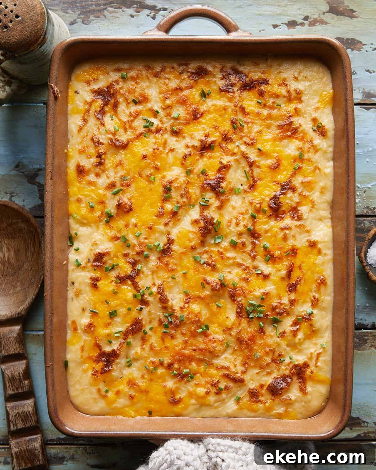 Overhead image of cheesy mashed potatoes with garnish. 