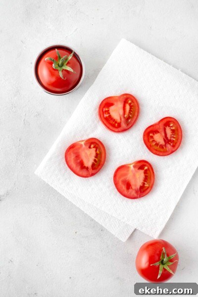 Cut cocktail tomatoes placed on a sheet of paper towel.
