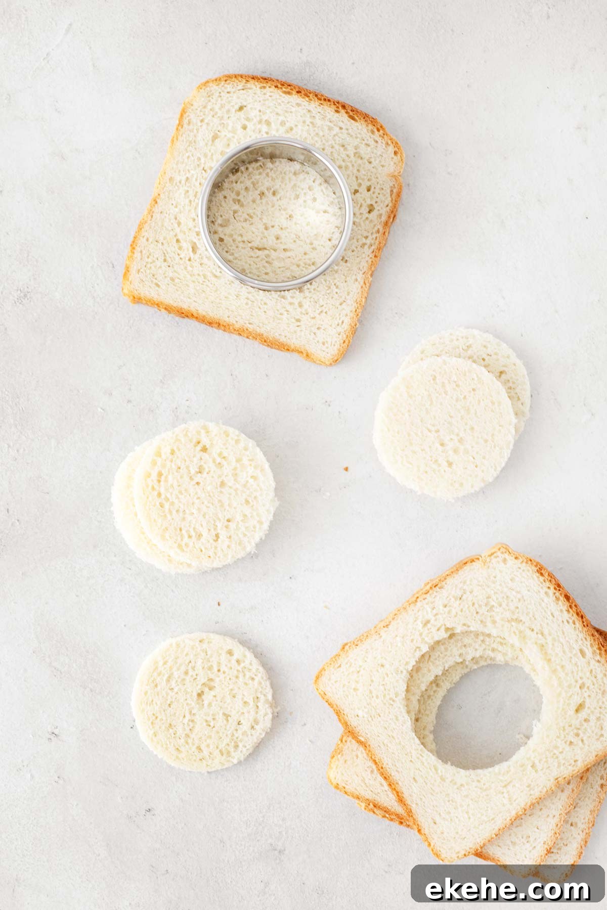 White bread being cut into circles with a round cookie cutter.