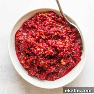 Cranberry Orange Relish served in a white bowl with a silver spoon.