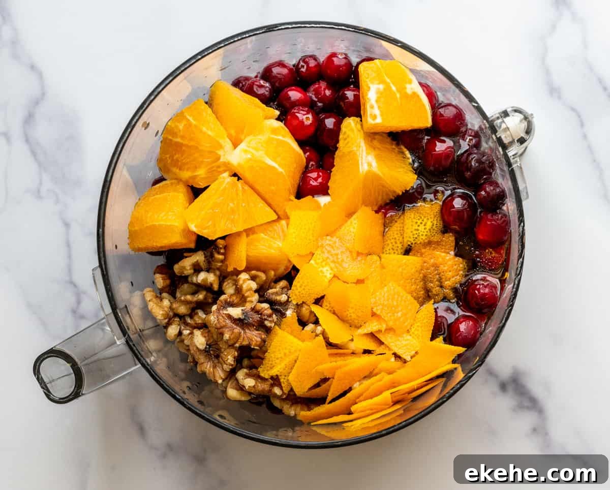 cranberry orange relish ingredients in food processor bowl.
