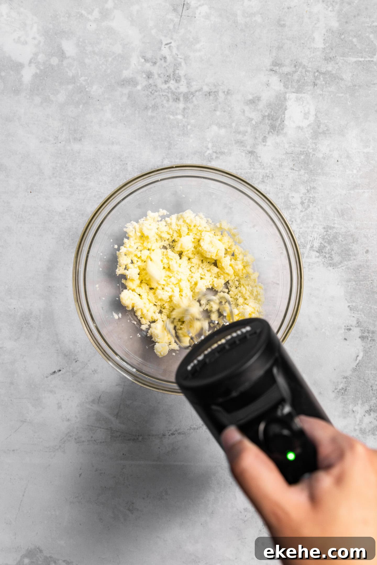 Butter and sugar being creamed together by a hand mixer