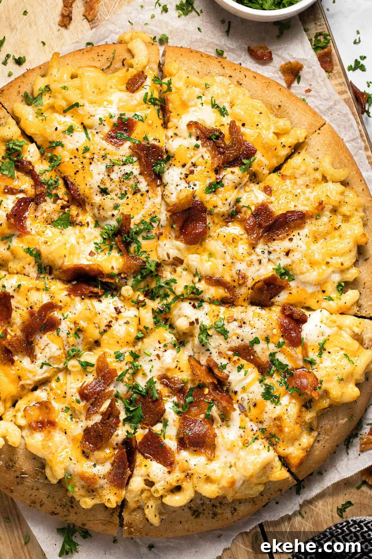 Homemade mac and cheese pizza on a wooden cutting board