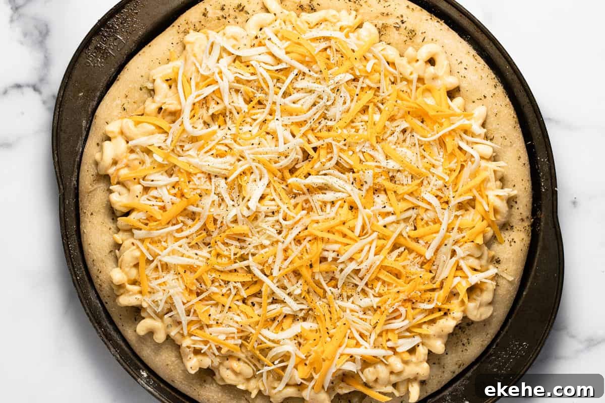 Mac and cheese pizza on a pizza pan just before baking it