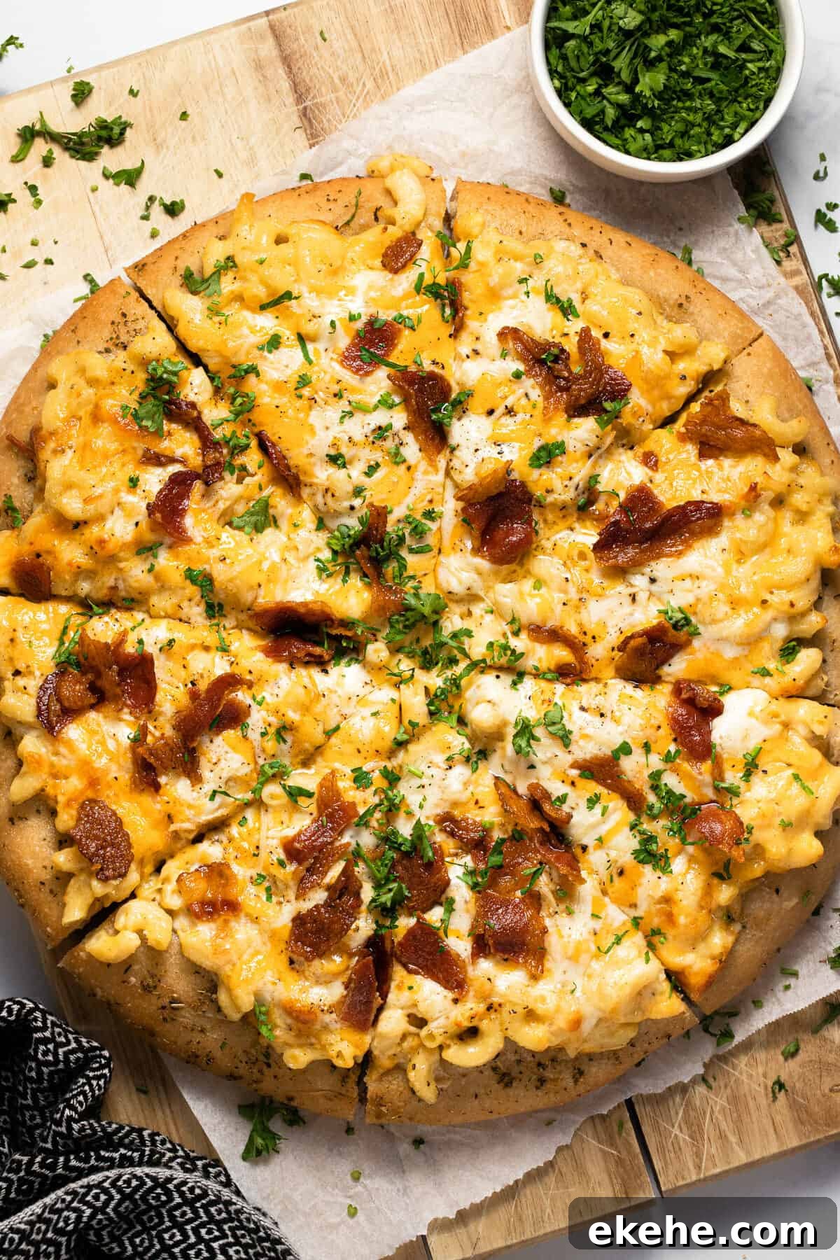 Homemade mac and cheese pizza on a wooden cutting board
