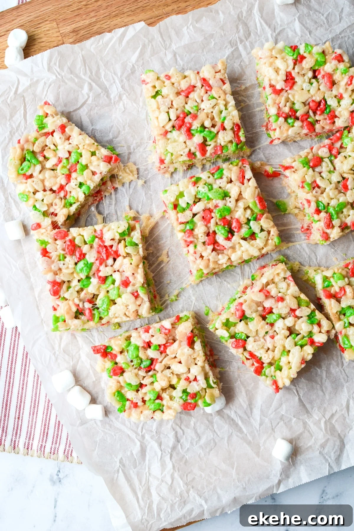 9 cereal treats place on a piece of parchment on top of a cutting board.