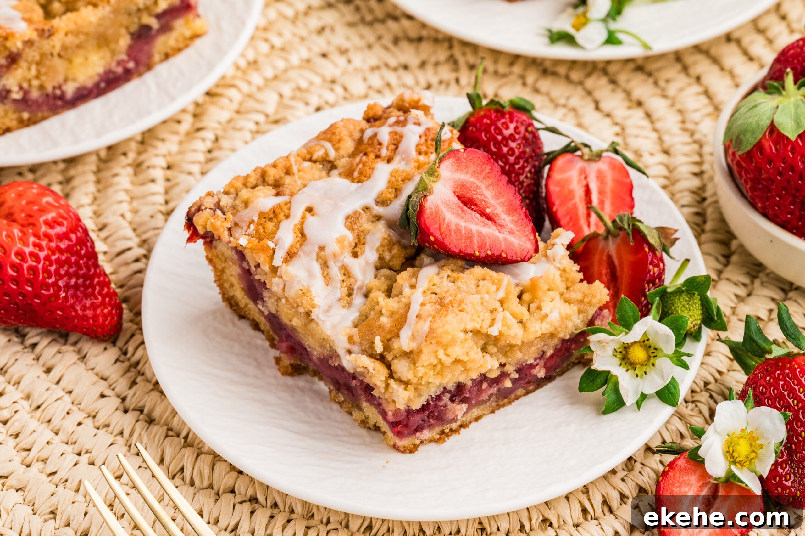overhead shot of the Strawberry Coffee Cake on a white plate with sliced strawberries 