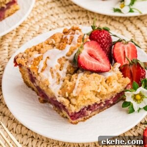 slice of Strawberry Coffee Cake on plate garnished with strawberries and flowers