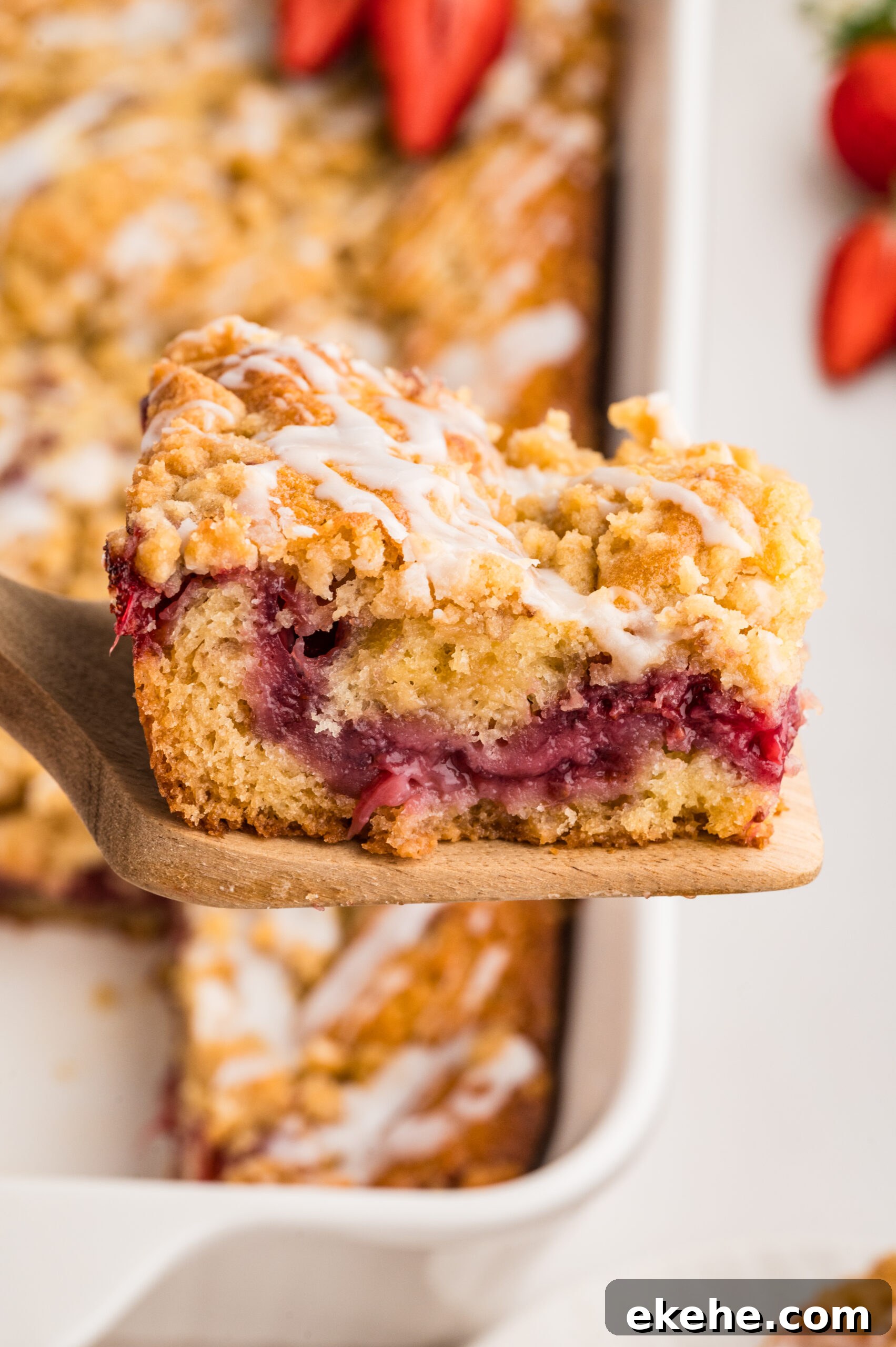 Strawberry Coffee Cake on a wooden spatula being lifted up