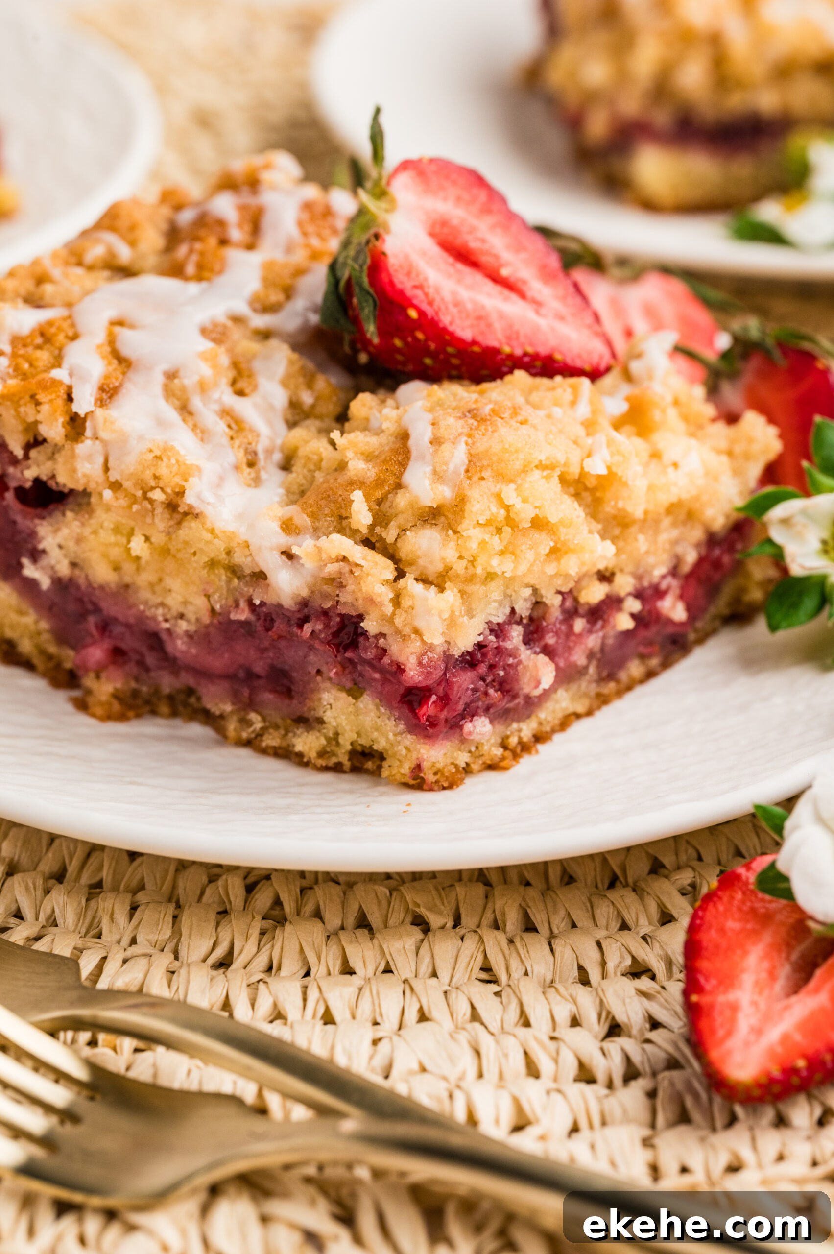 Strawberry Coffee Cake on a white plate with sliced strawberries 