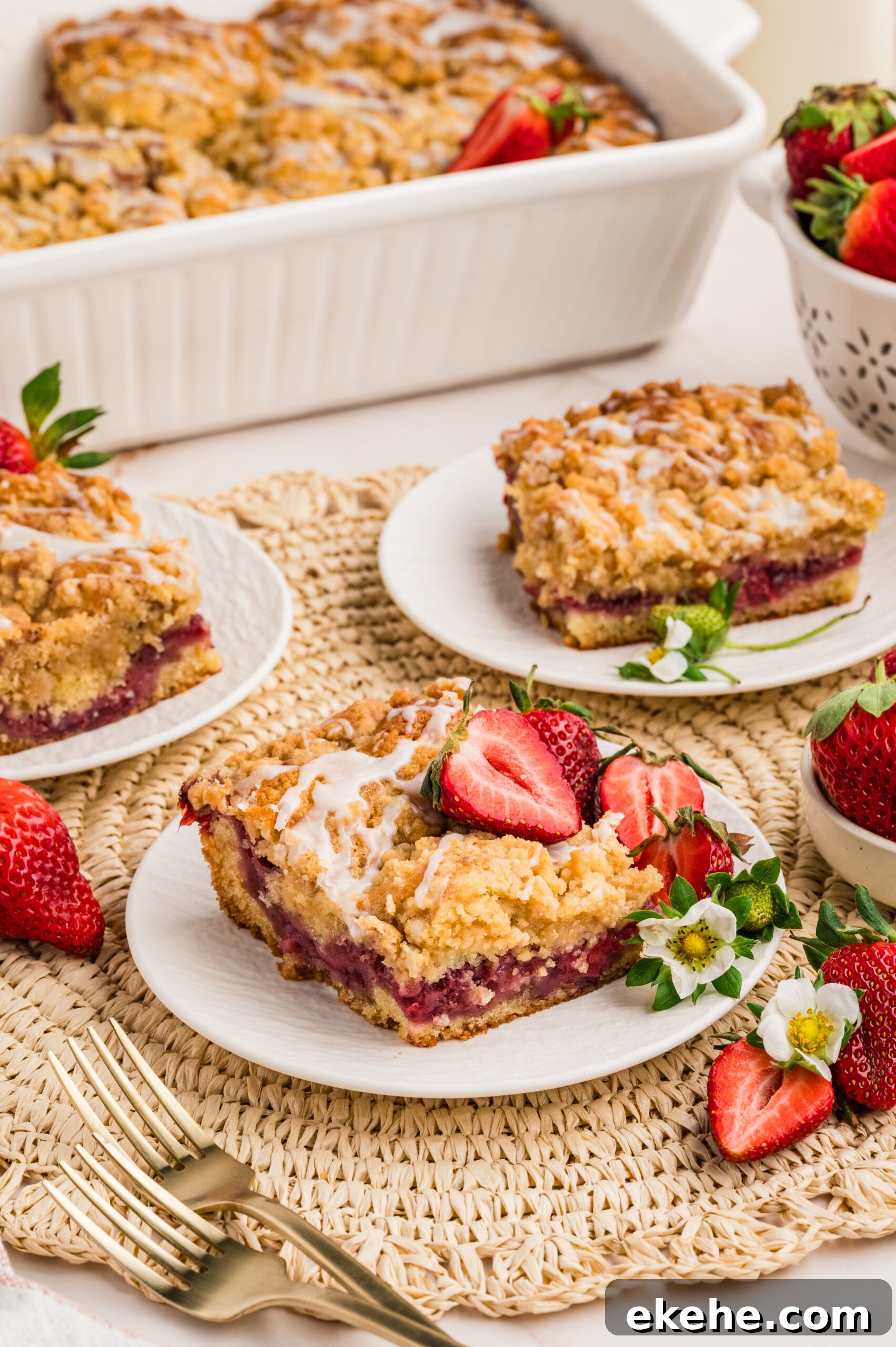 Strawberry Coffee Cake on a white plate with sliced strawberries and little flowers
