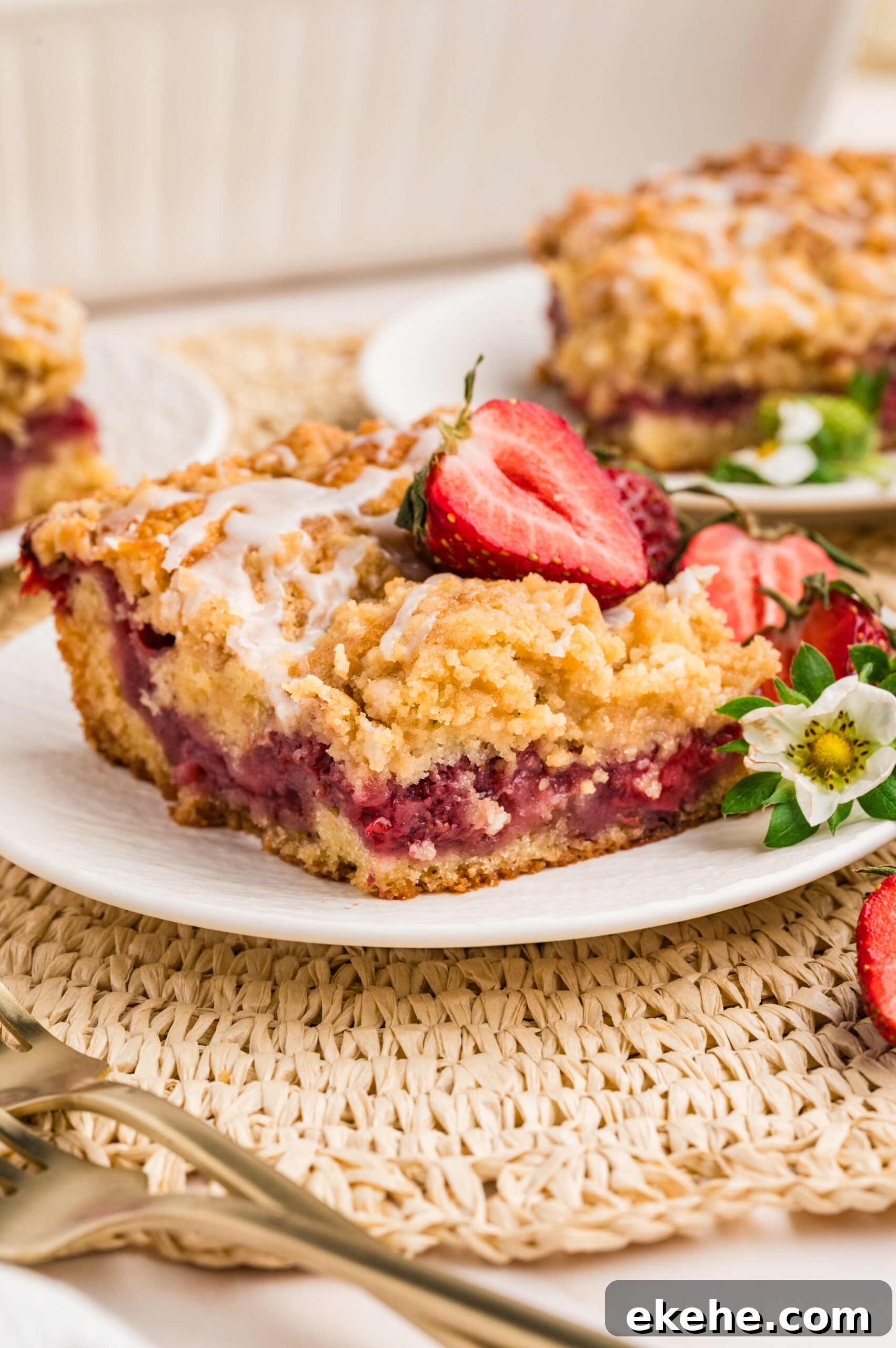 up close shot of the Strawberry Coffee Cake on a white plate with sliced strawberries 